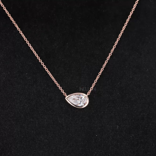 East to west pear cut moissanite solitaire necklace in bezel setting – modern twist on classic drop pendant