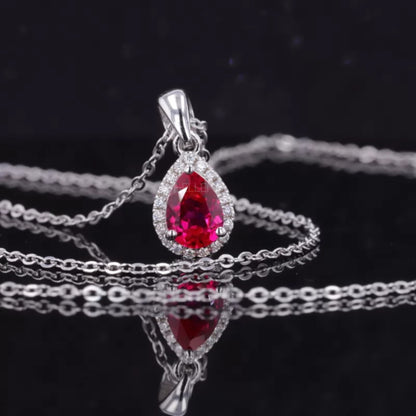 Halo pendant necklace featuring pink pear cut ruby and colorless moissanite – vibrant and luxurious gemstone design

