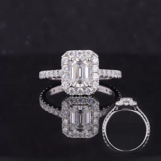 Emerald cut moissanite center with round halo accents – bold geometric elegance in an engagement ring