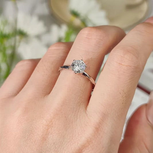 Round cut moissanite solitaire ring with twisted shank engagement design