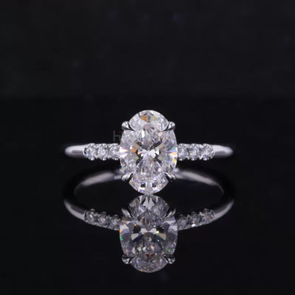 Oval cut moissanite solitaire ring with round side stones in claw prong setting – elegant three-stone engagement design