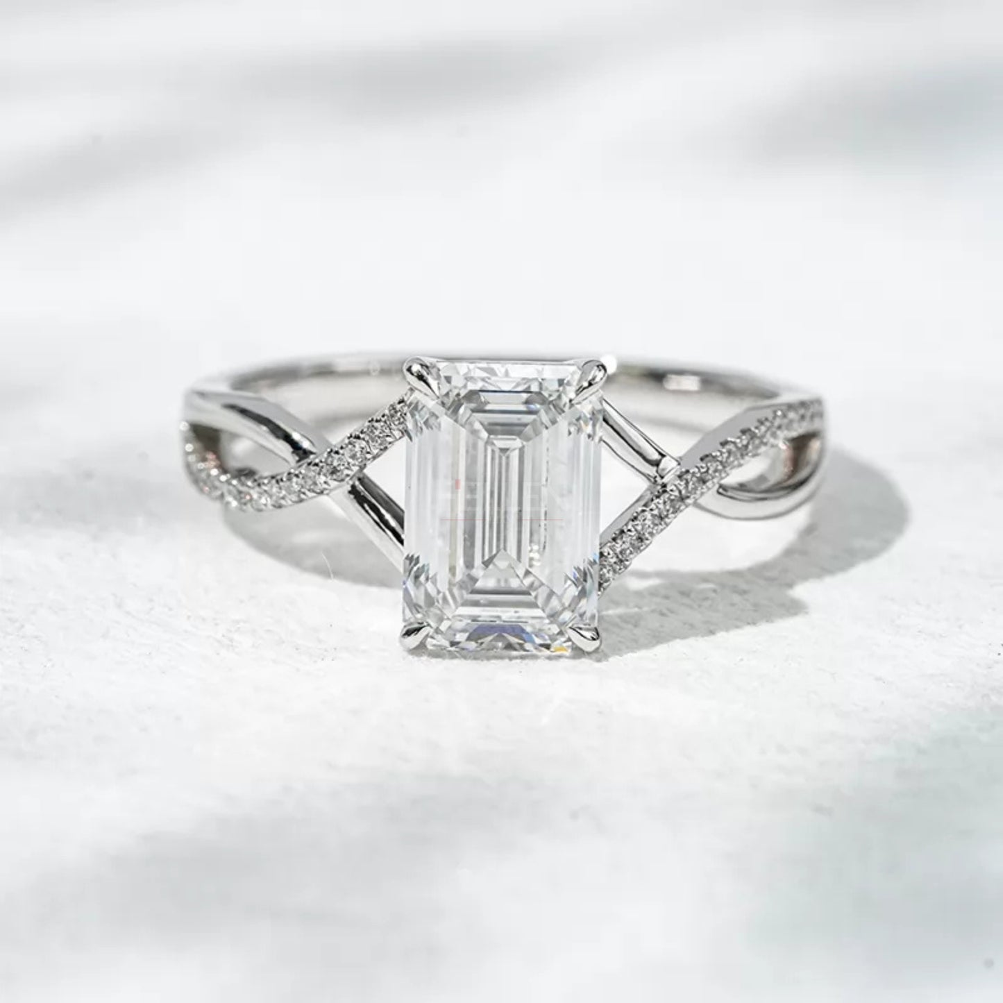 Emerald gemstone solitaire wedding ring with crossed shank – elegant and symbolic bridal design
