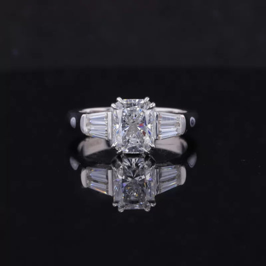 Emerald cut moissanite engagement ring with tapered baguette side stones – classic three-stone design