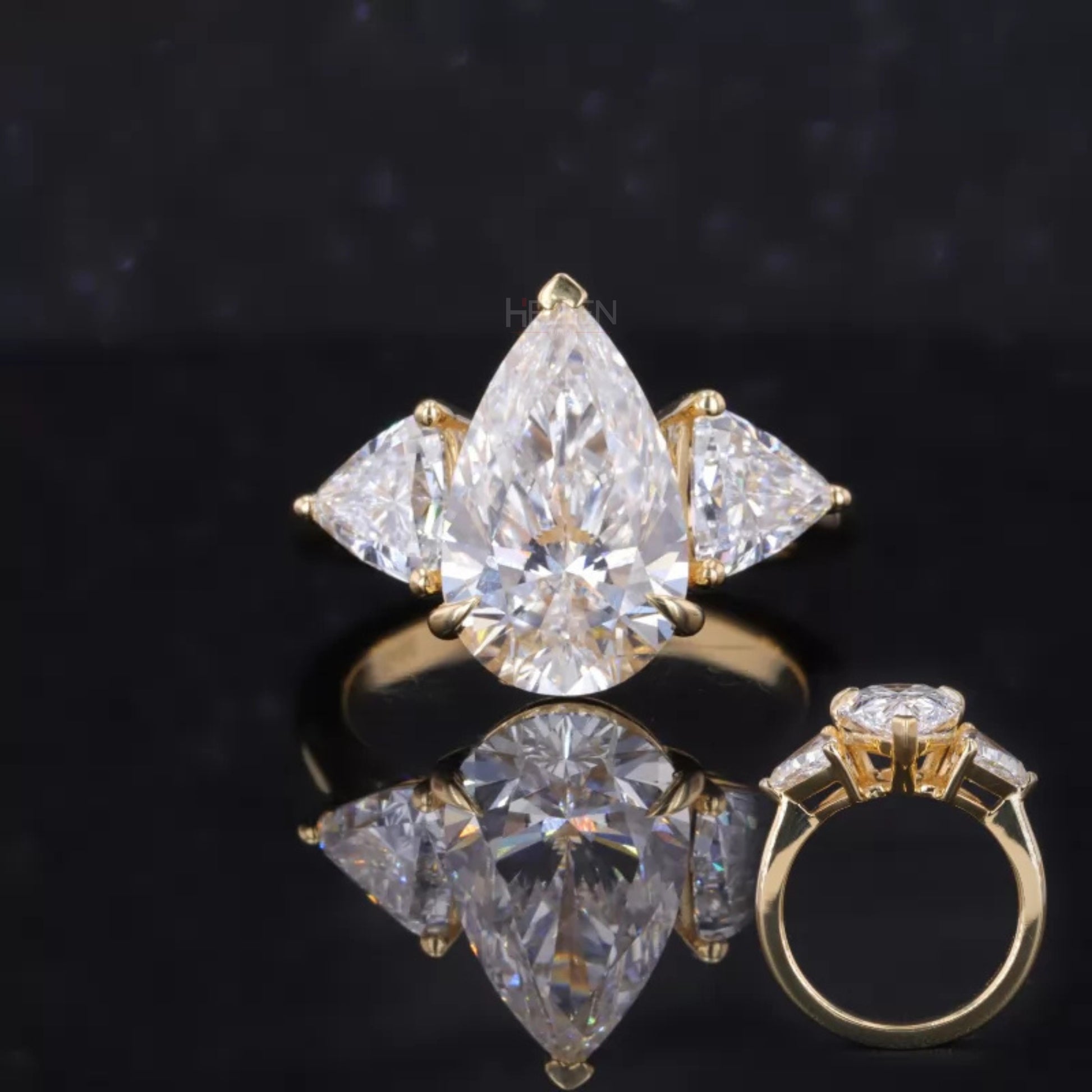 3 stone pear cut moissanite engagement ring with trillion side stones – modern twist on classic design

