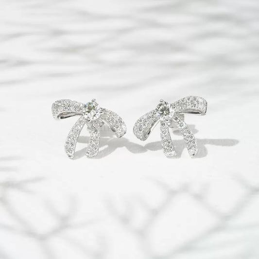 Elegant sterling silver moissanite stud earrings with ribbon bow design