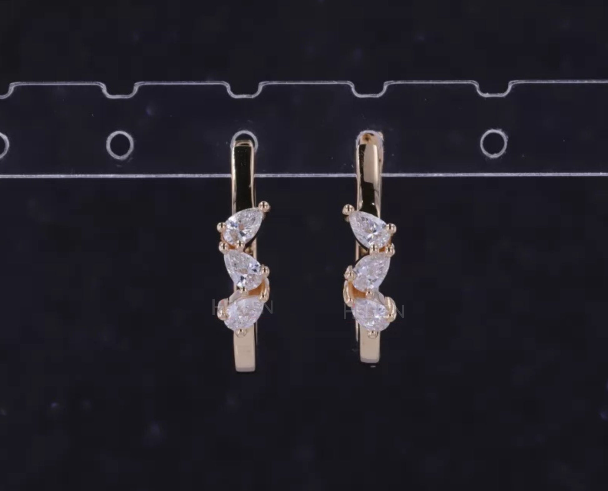 Hoop earrings with three-stone setting and pear cut solitaire – modern elegance with dynamic design