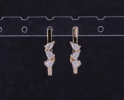 Hoop earrings with three-stone setting and pear cut solitaire – modern elegance with dynamic design