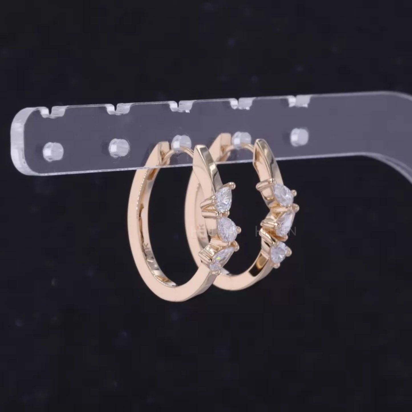 Hoop earrings with three-stone setting and pear cut solitaire – modern elegance with dynamic design