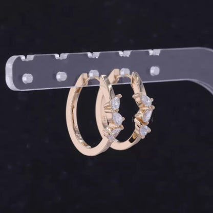 Hoop earrings with three-stone setting and pear cut solitaire – modern elegance with dynamic design